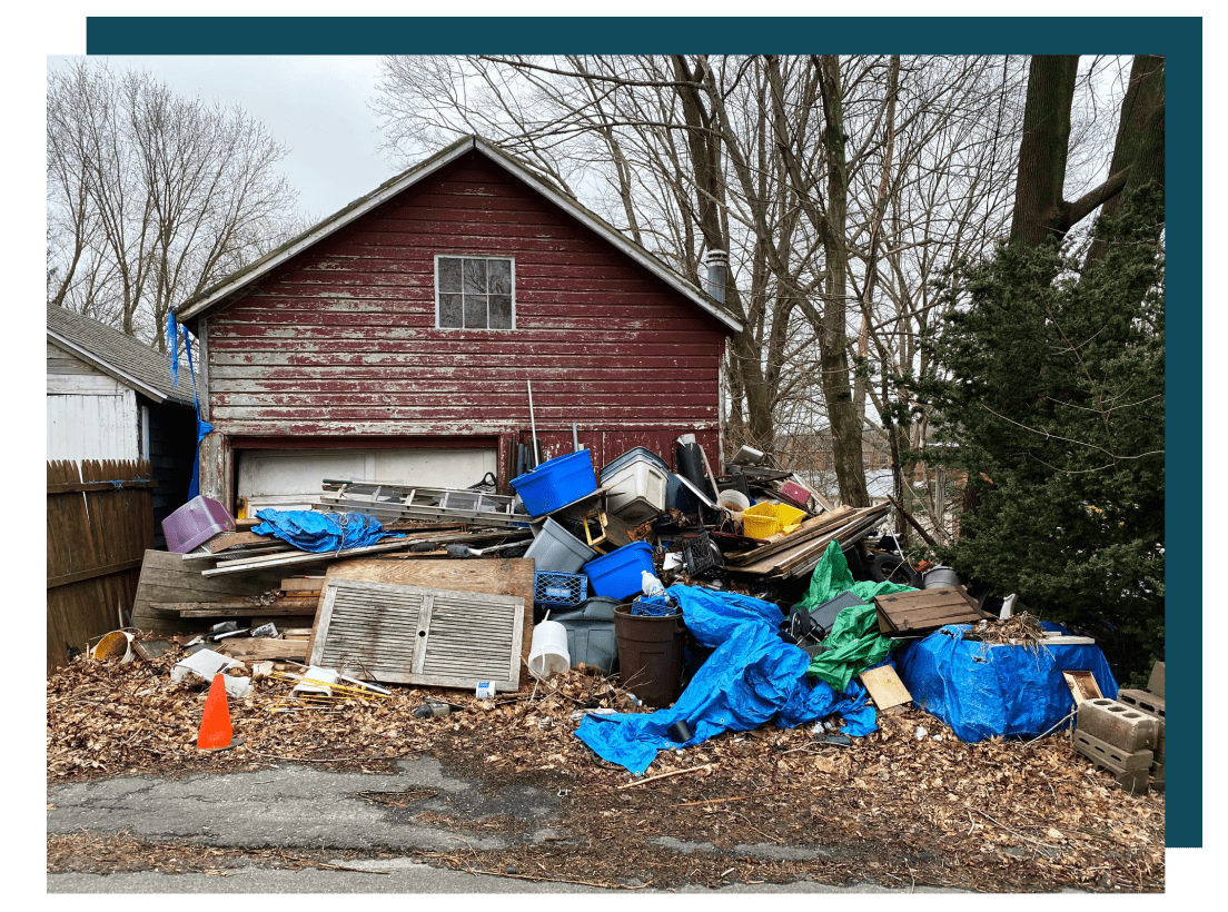 A pile of trash sitting in front of a house.